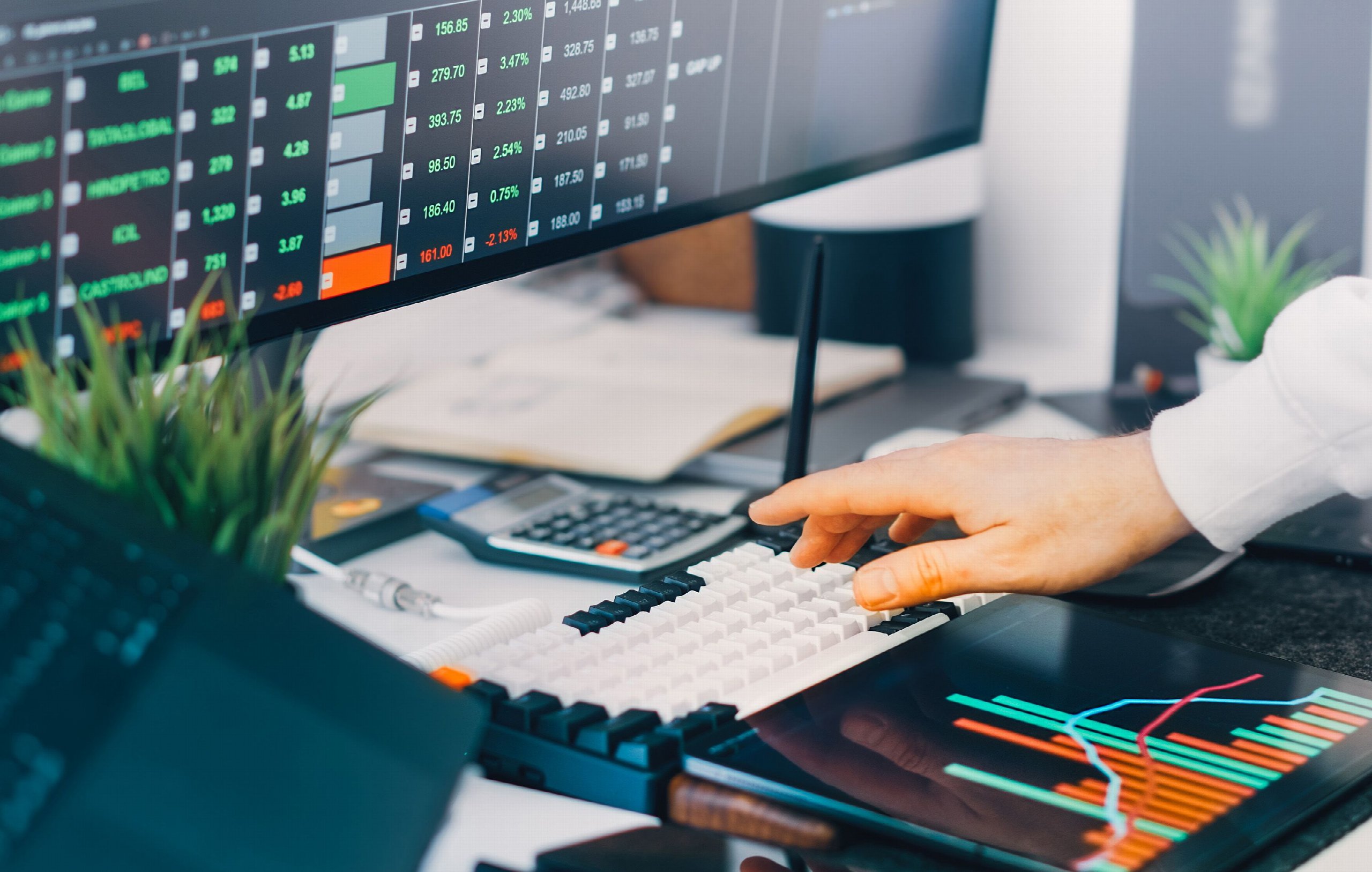 Professional trading workspace with stock market charts and financial data on multiple screens