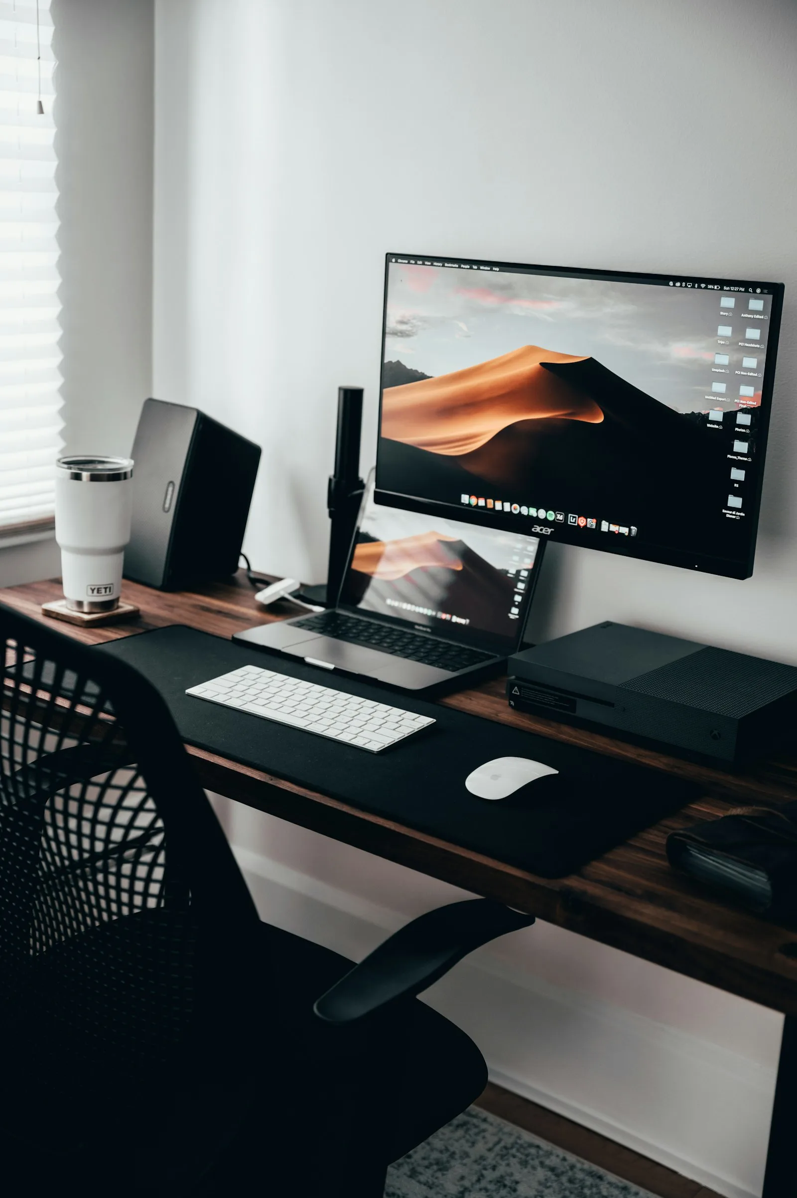 Home office workspace with a laptop, monitor and keyboard on a wooden desk