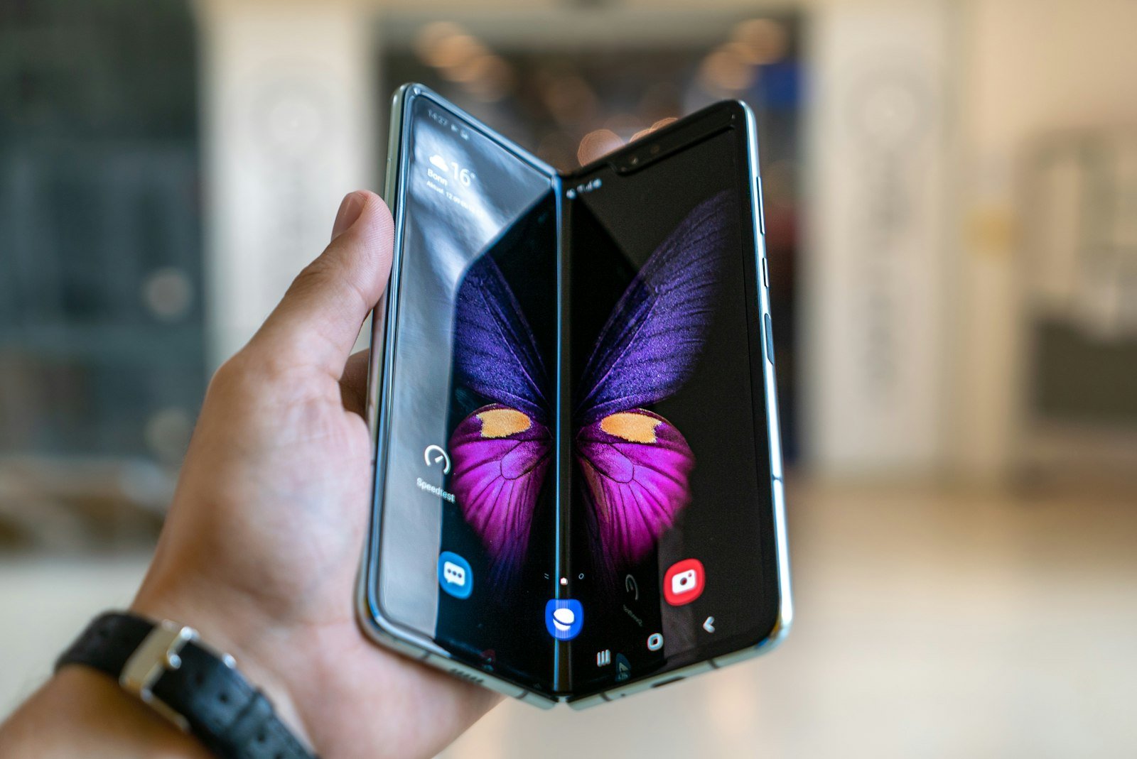 Person holding a black foldable phone in one hand