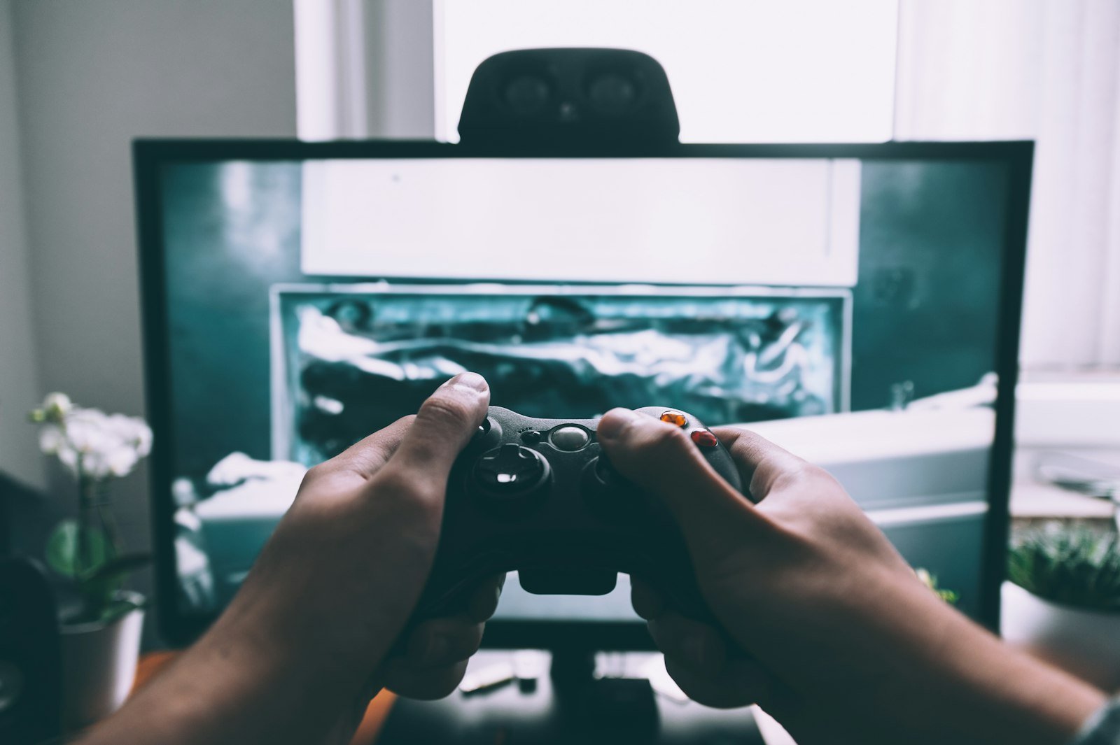 Person holding a game controller in front of a television